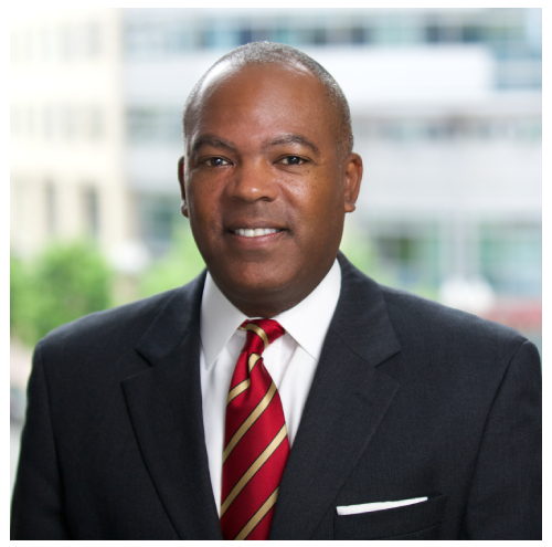 A man in a suit and tie standing outside.