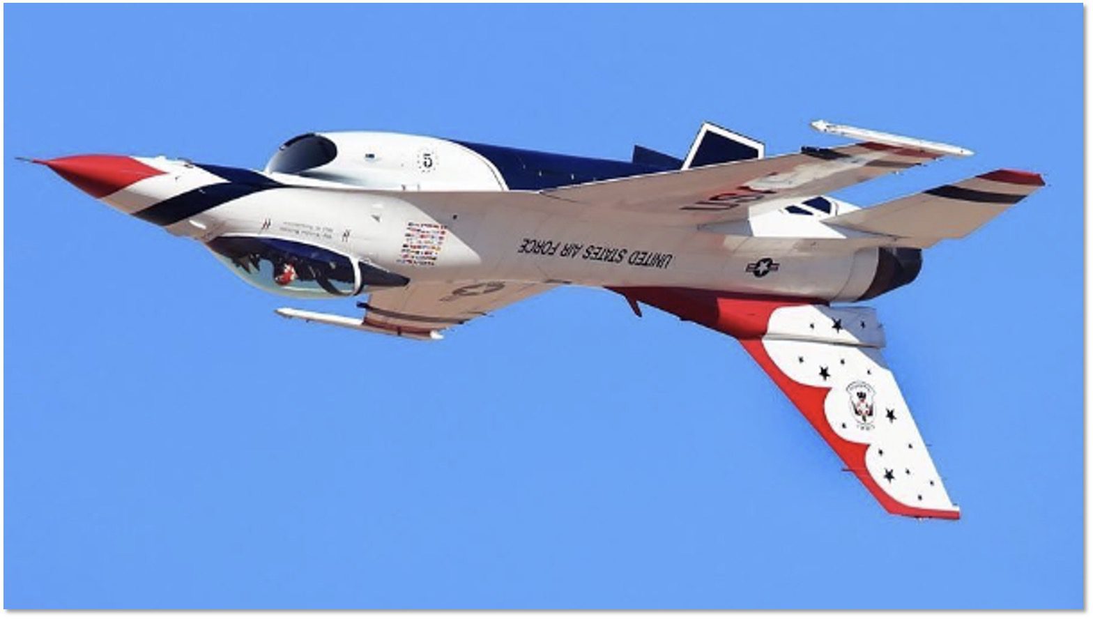 A fighter jet flying through the air with its landing gear down.