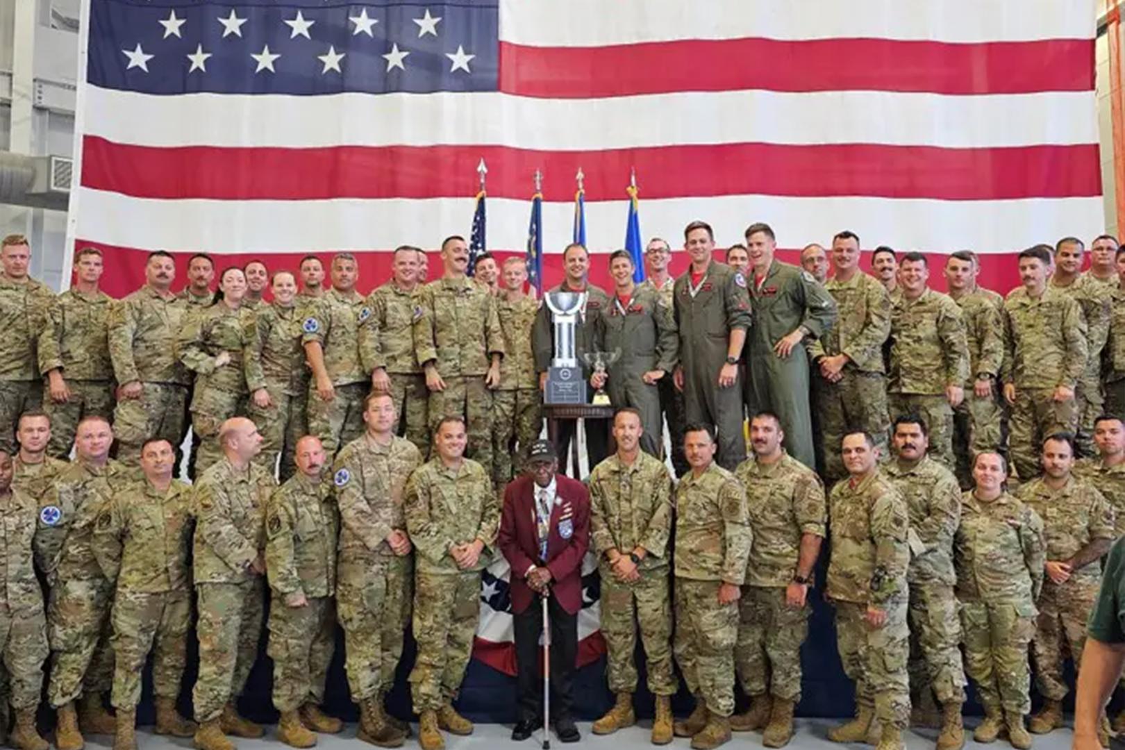 A group of soldiers in front of an american flag.