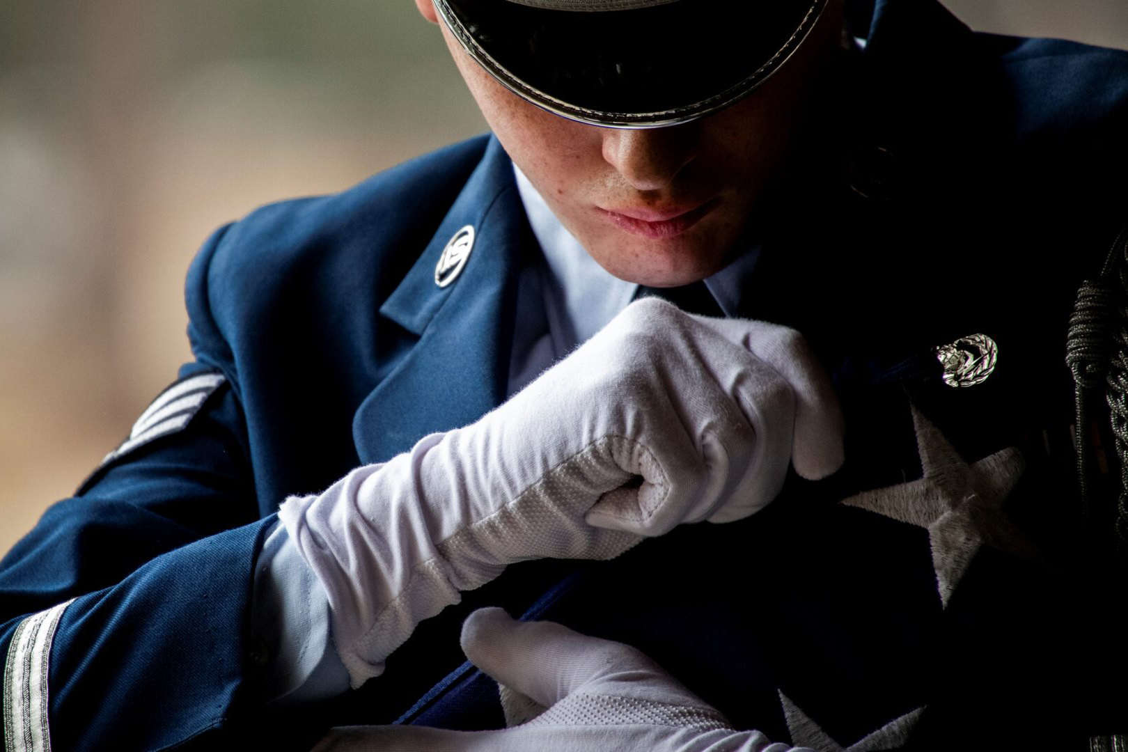 A man in uniform putting on gloves.