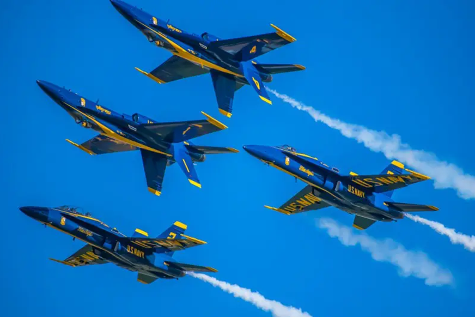 A group of jets flying in formation with smoke coming out.