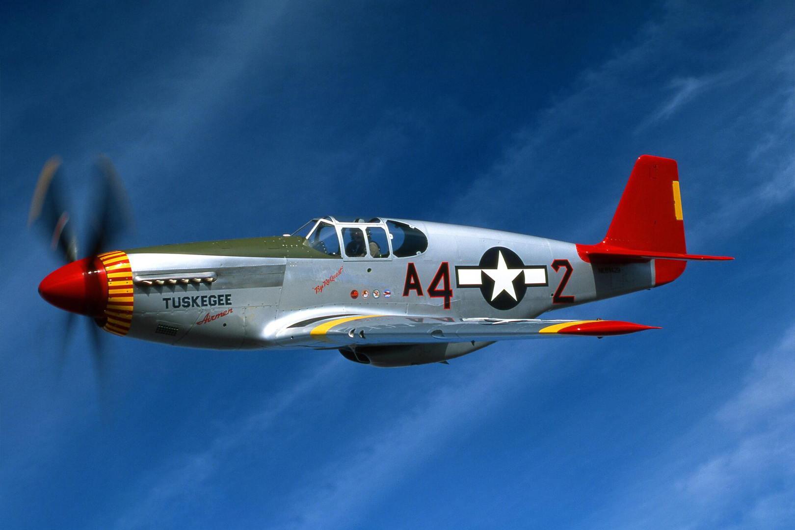 A silver and red fighter jet flying in the sky.